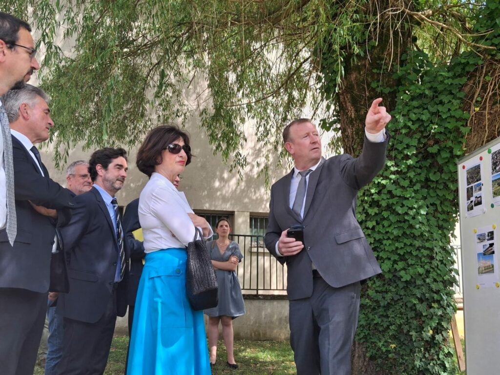 Alain Darbon montre les futurs aménagements extérieurs à la Préfète de Région Sophie Brocas et à la délégation, sur le site de l'ancien hôpital.